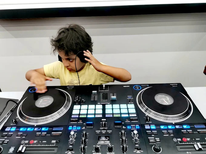 Child learning DJing at DJ World showroom in Bahrain on AlphaTheta Pioneer DJ controller