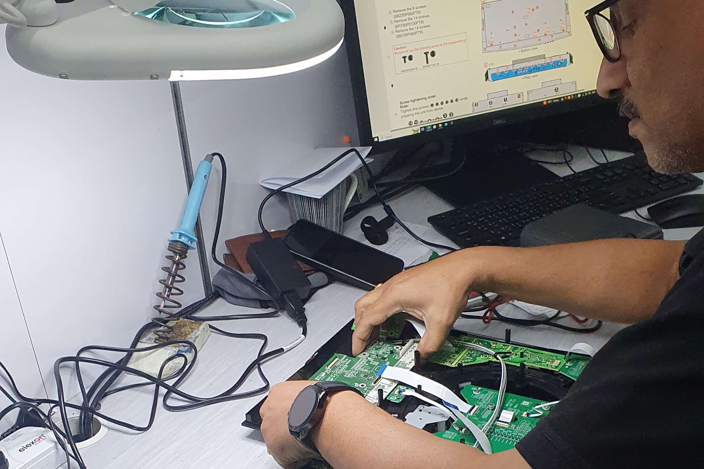 DJ World technician repairing Pioneer DJ equipment at the service centre in Juffair
